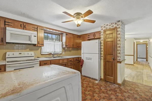 a kitchen with stainless steel appliances granite countertop a refrigerator a stove and a sink