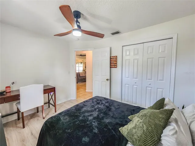 a bedroom with a bed and a flat tv screen on the dresser