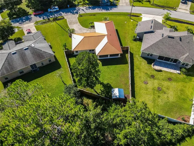 an aerial view of a house with swimming pool and garden