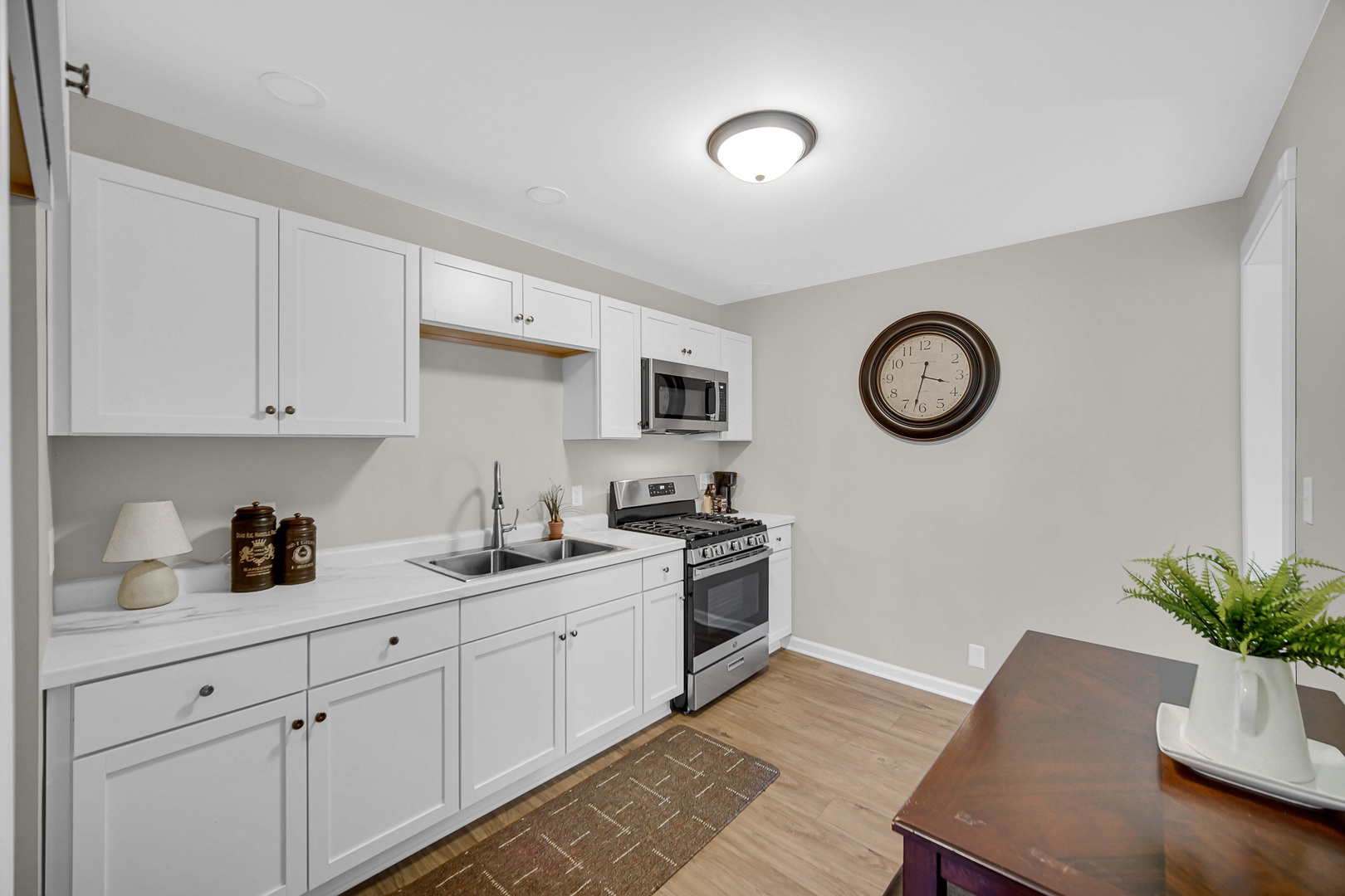 1376 Lennington Circle Northwest Kankakee, IL 60901 - Photo 6 of 16 a kitchen with a clock on the cabinets and wooden floor