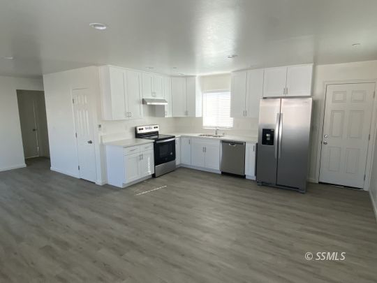 206 West Robertson Road Ridgecrest, CA 93555 - Photo 3 of 6 a kitchen with stainless steel appliances a refrigerator sink and stove