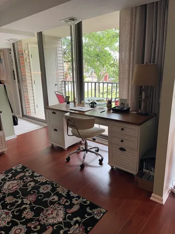 a view of a workspace with furniture and a window