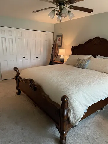 a bed room with a bed and a ceiling fan