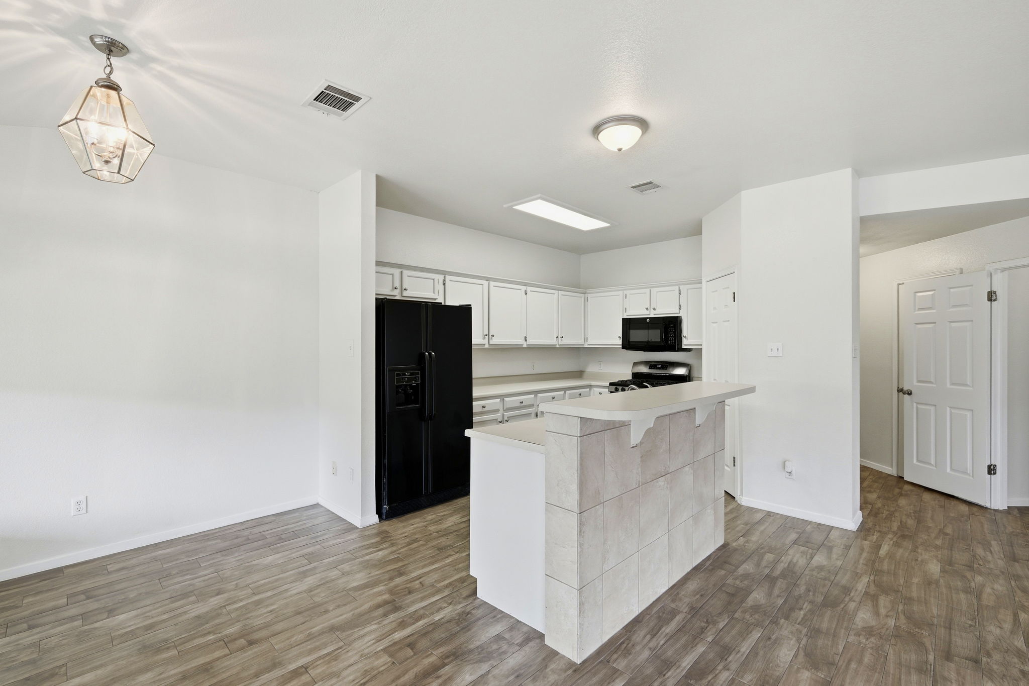 1005 Rolling Ridge Drive Round Rock, TX 78665 - Photo 5 of 18 A well-lit kitchen with a tiled breakfast bar offers a welcoming, functional space.