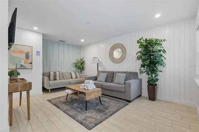 a living room with furniture a clock and a potted plant