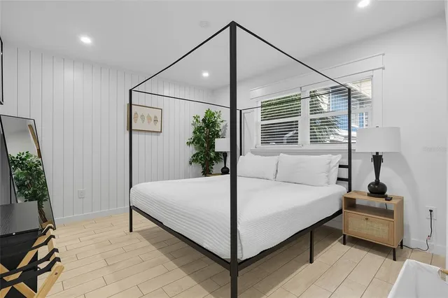 a bedroom with a bed and a potted plant