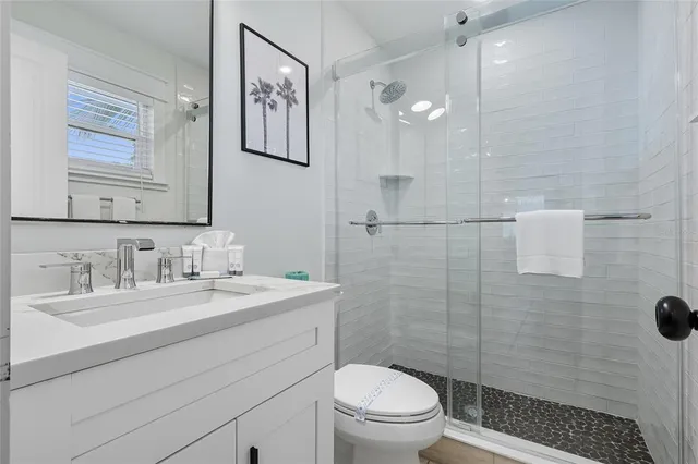 a bathroom with a sink a toilet and shower