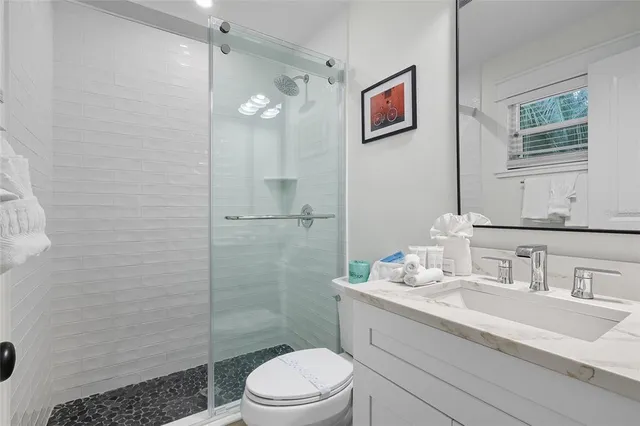 a bathroom with a sink a toilet and shower