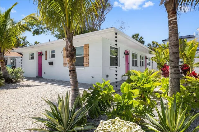 a front view of a house with a yard and potted plants