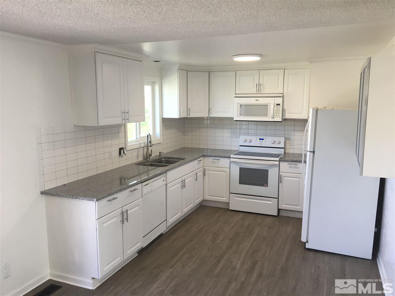 3951 West 7th Street Reno, NV 89503 - Photo 2 of 17 a kitchen with white cabinets stainless steel appliances and sink