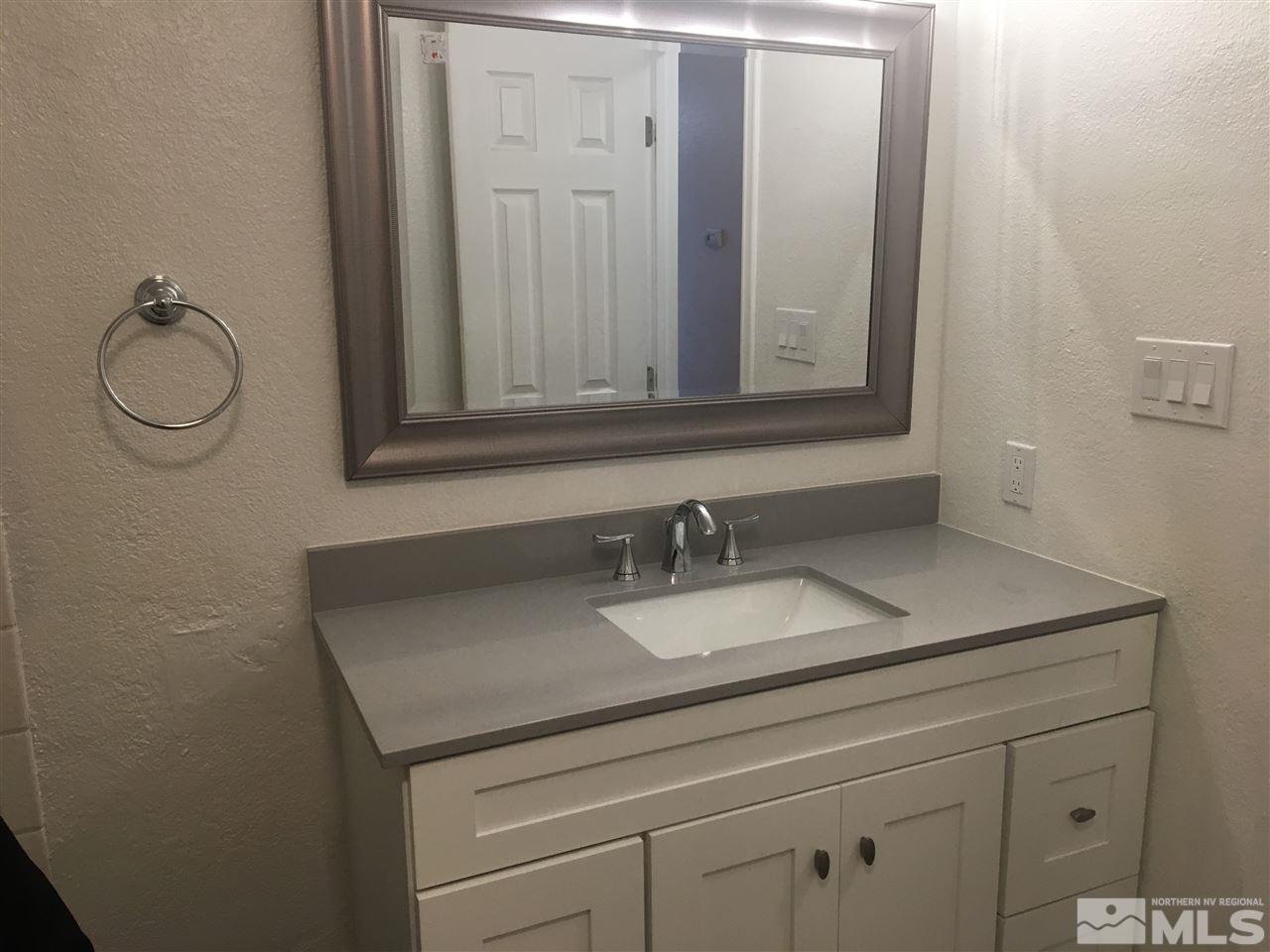 3951 West 7th Street Reno, NV 89503 - Photo 7 of 17 a bathroom with a granite countertop sink and a mirror