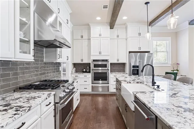 a kitchen with stainless steel appliances kitchen island granite countertop a stove a sink and a refrigerator