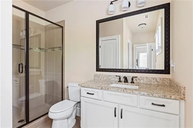 a bathroom with a granite countertop sink toilet and shower