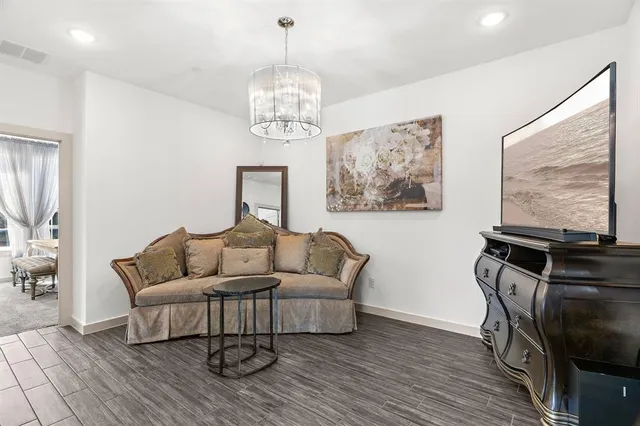 a living room with furniture a chandelier and a flat screen tv