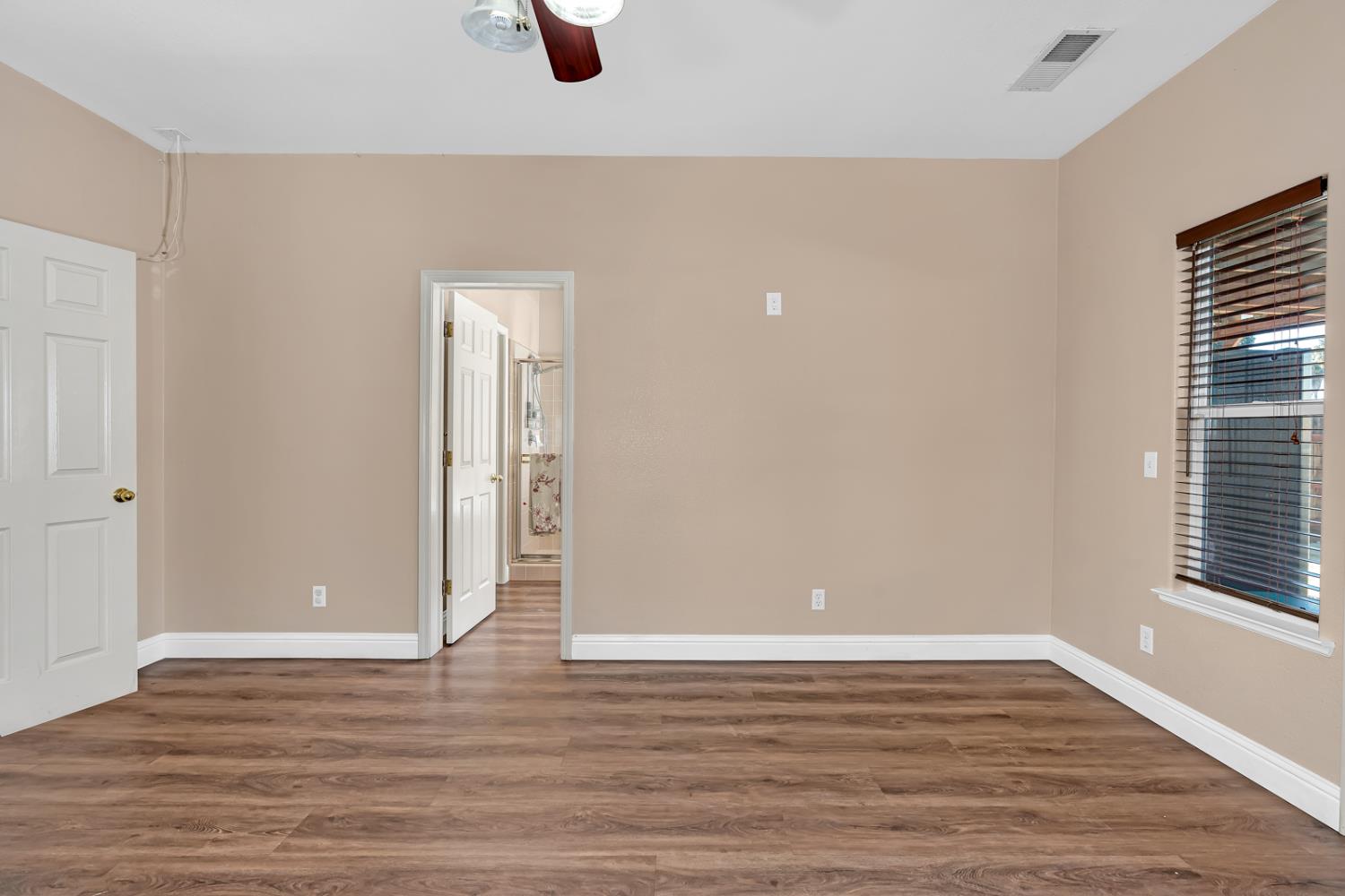 3877 Pintail Court Merced, CA 95340 - Photo 24 of 42 an empty room with wooden floor and windows