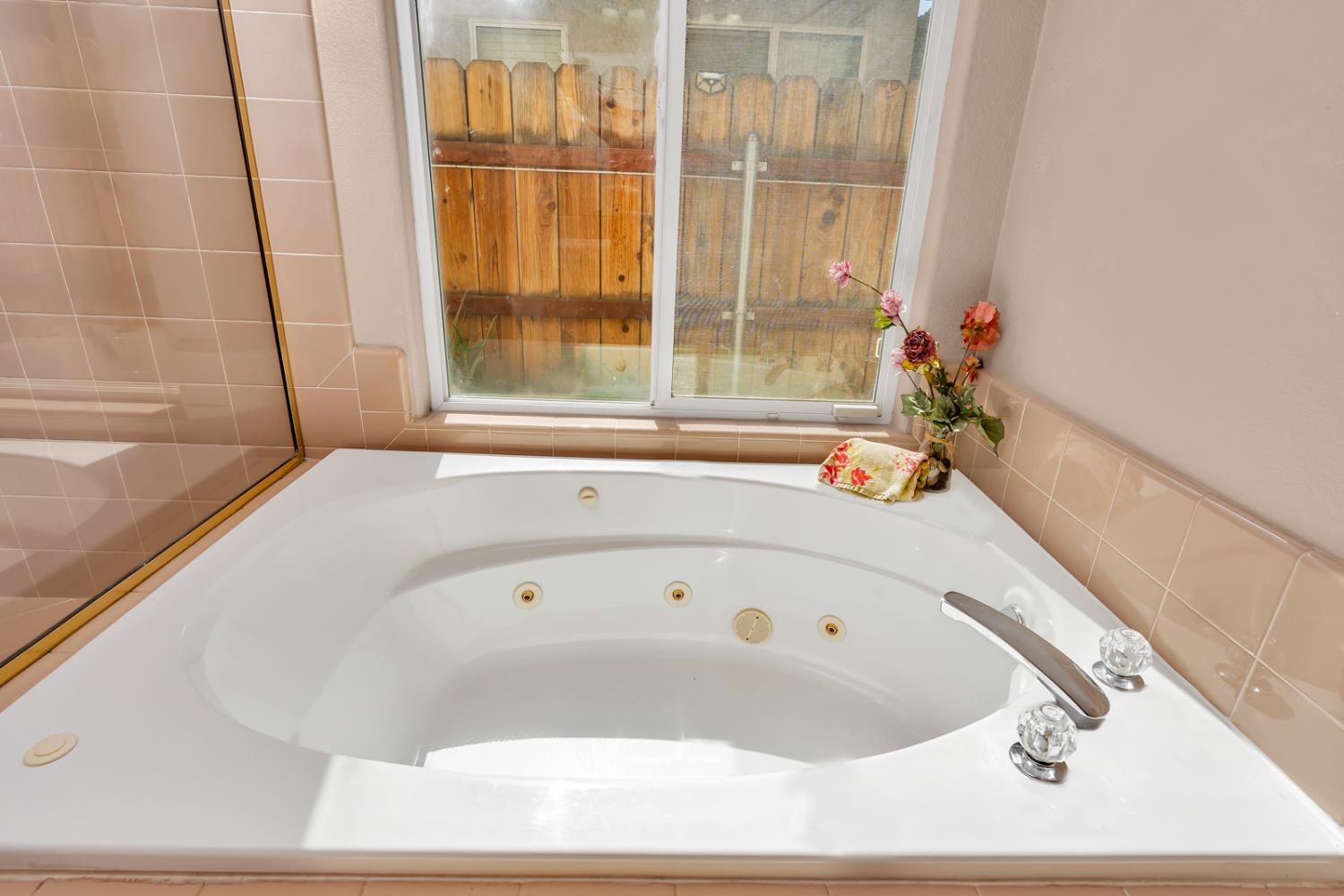 3877 Pintail Court Merced, CA 95340 - Photo 27 of 42 a white bath tub sitting in a bathroom next to a window