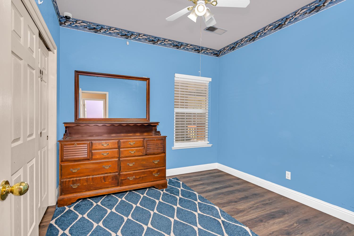 3877 Pintail Court Merced, CA 95340 - Photo 34 of 42 a room with a dresser and a chandelier