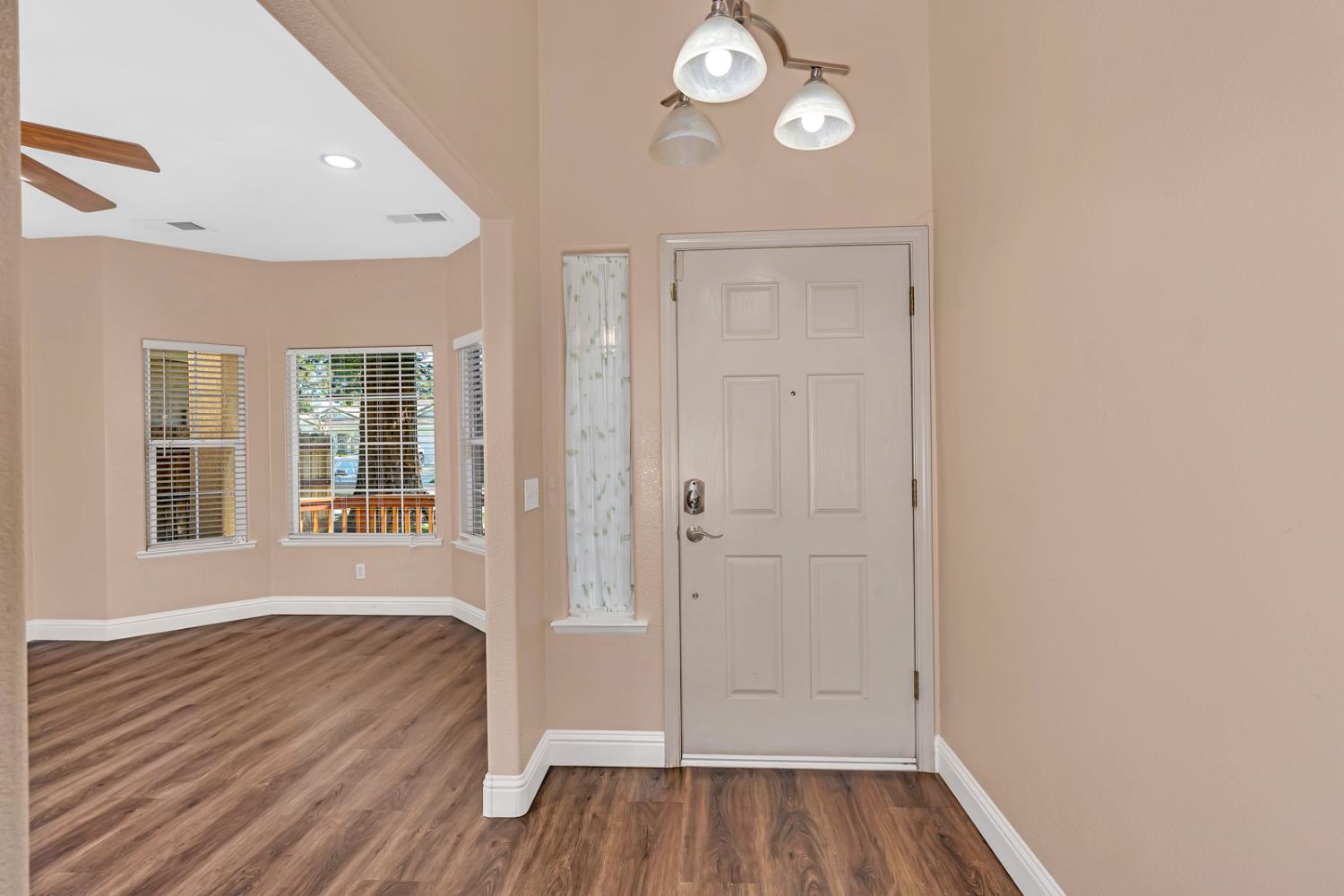 3877 Pintail Court Merced, CA 95340 - Photo 7 of 42 a view of an empty room with wooden floor and a window