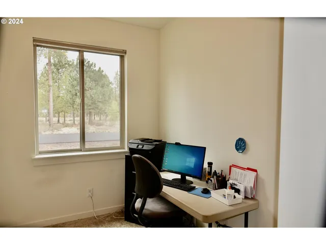 a work place with computer on desk and a window