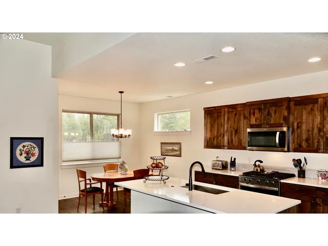 a kitchen with a sink a counter top space appliances and a window