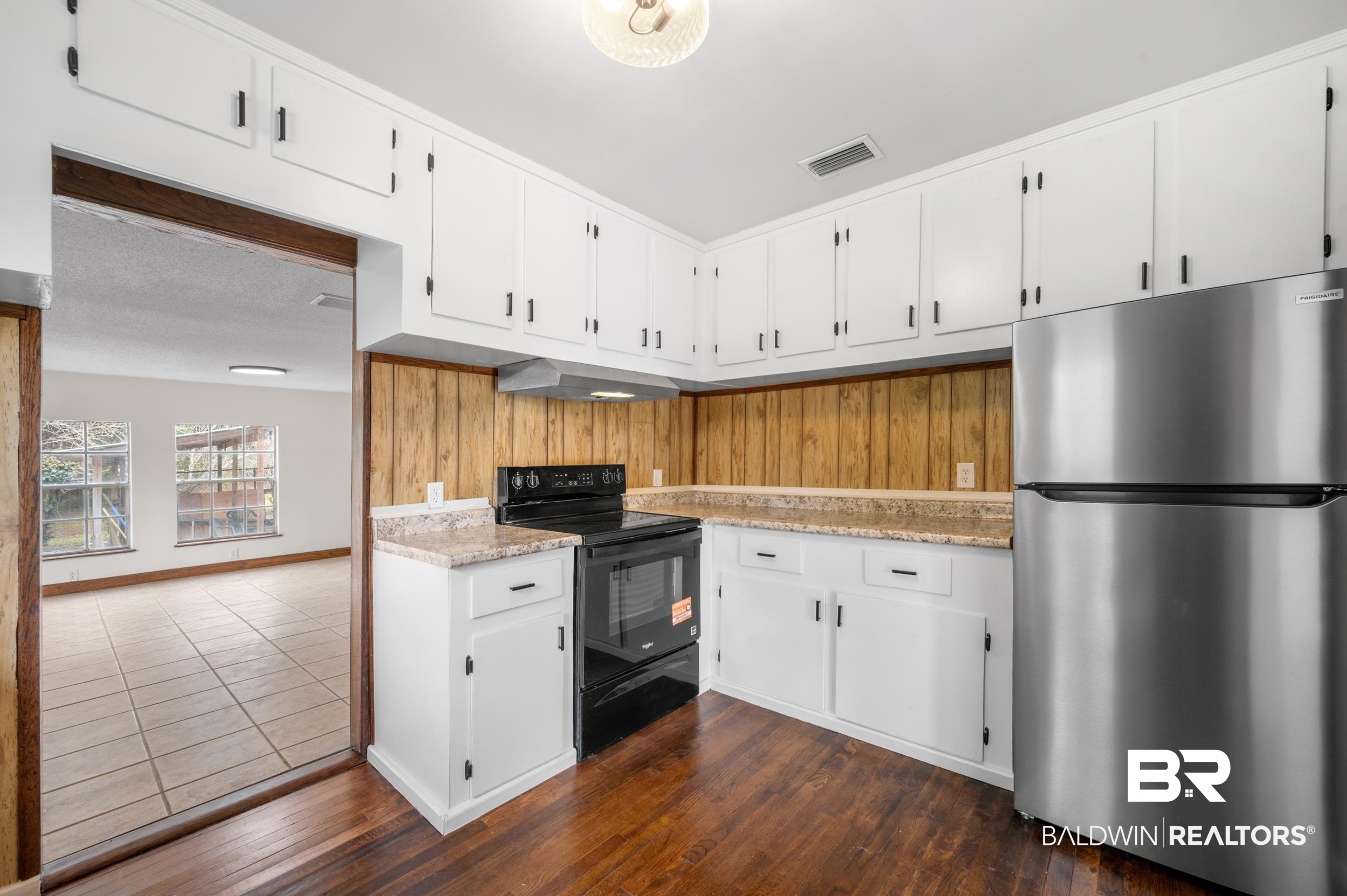 35780 Spring Road North Stapleton, AL 36578 - Photo 16 of 41 Kitchen featuring white cabinets, freestanding refrigerator, black electric range oven, dark wood finished floors, and under cabinet range hood