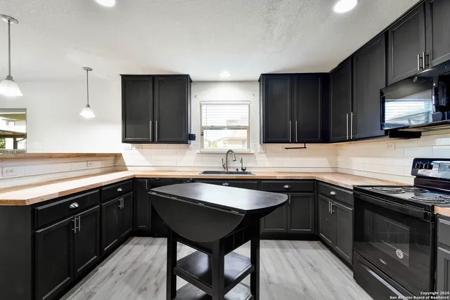 a kitchen with a sink cabinets and wooden floor