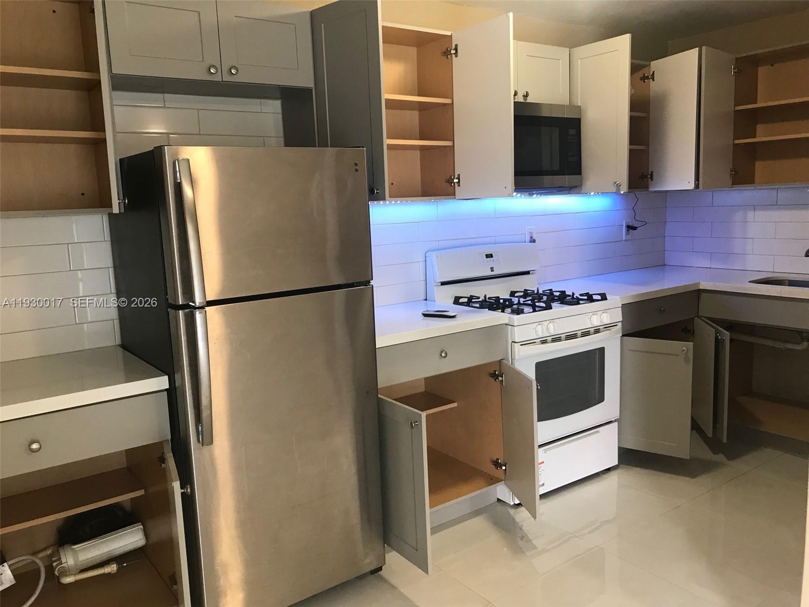 a kitchen with stainless steel appliances a stove a refrigerator and cabinets