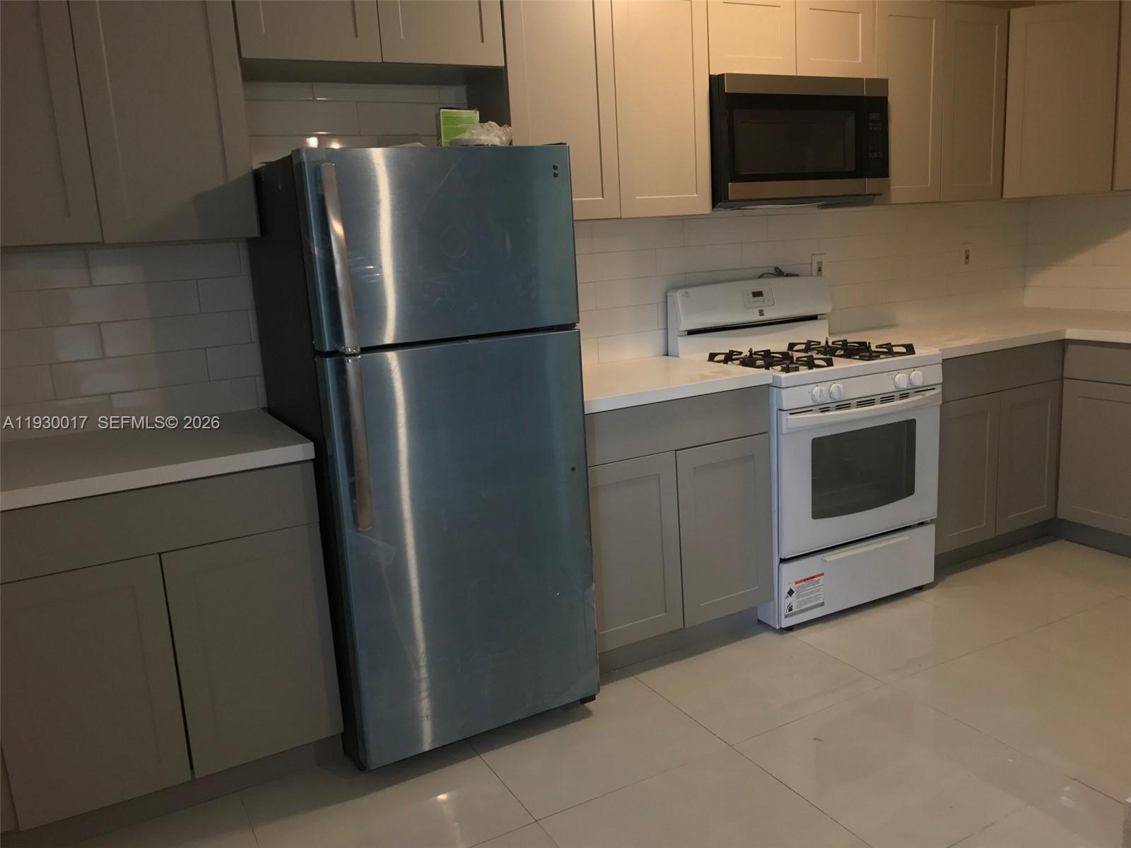4550 Southwest 67th Avenue, Unit 7 Miami, FL 33155 - Photo 17 of 25 a kitchen with stainless steel appliances white cabinets white and a refrigerator