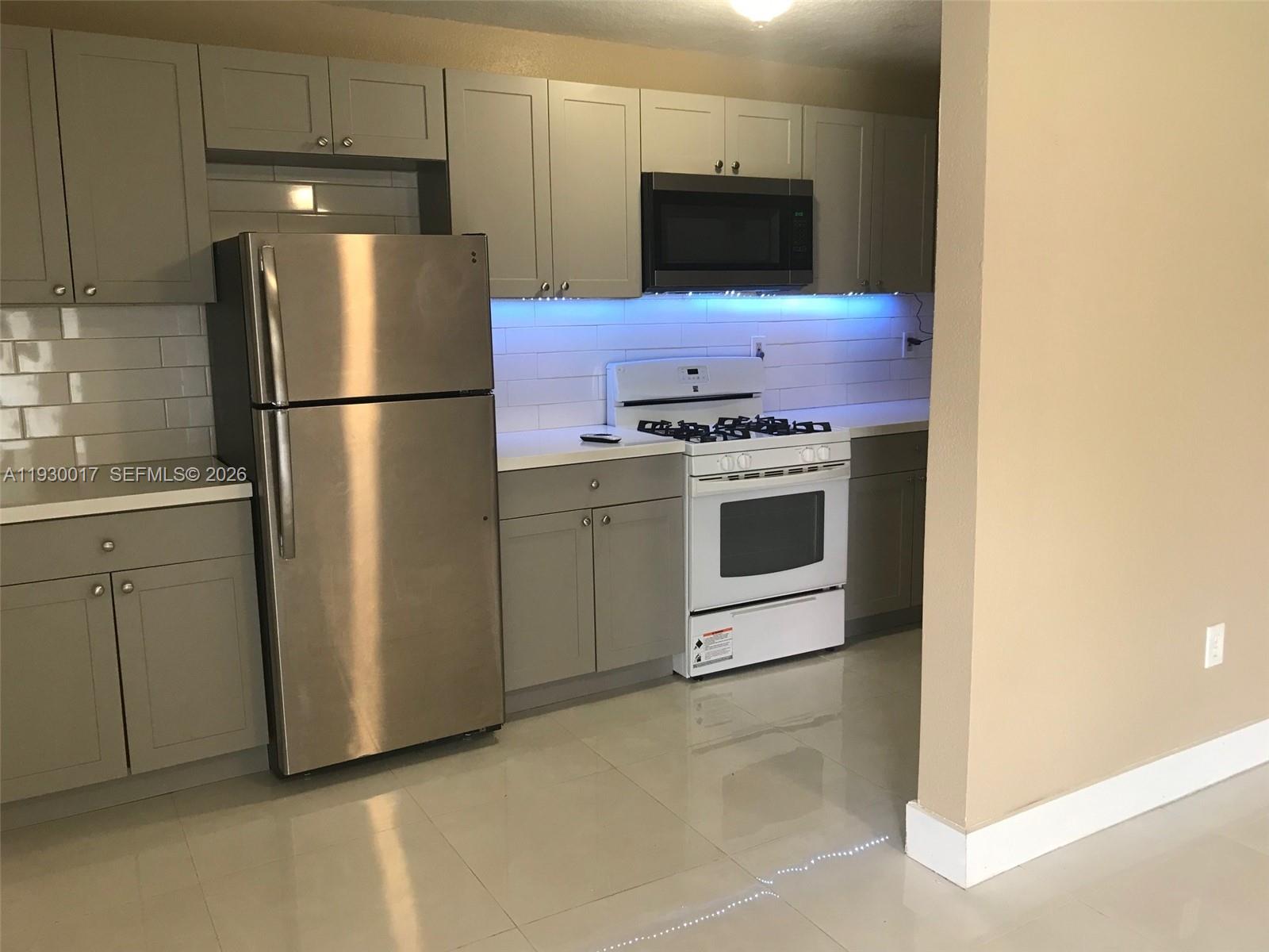 4550 Southwest 67th Avenue, Unit 7 Miami, FL 33155 - Photo 4 of 25 a kitchen with stainless steel appliances a refrigerator stove and microwave