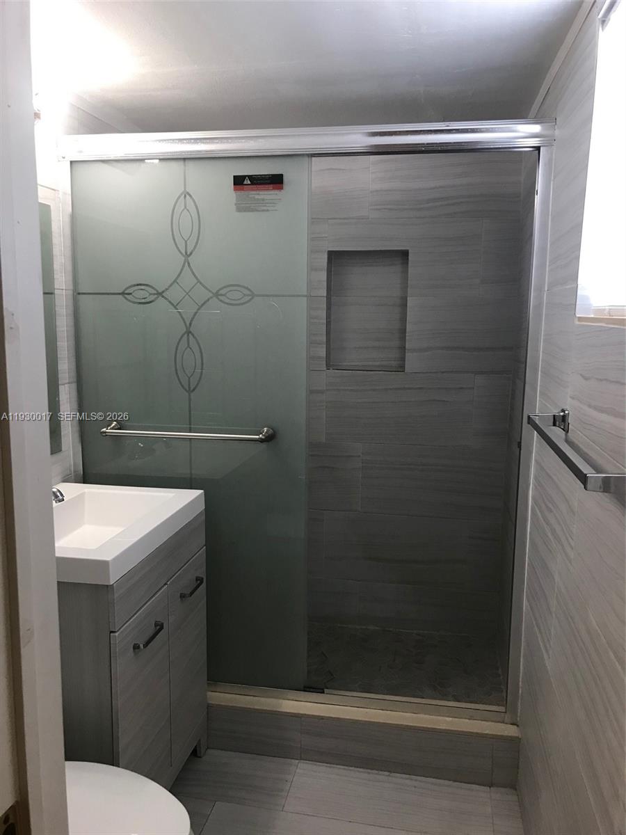 4550 Southwest 67th Avenue, Unit 7 Miami, FL 33155 - Photo 8 of 25 a bathroom with a sink a toilet and shower