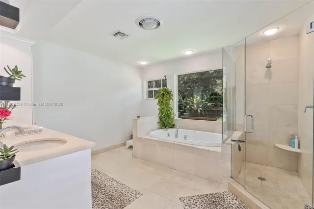 a bathroom with a tub a sink and a shower