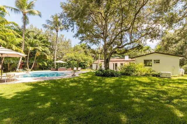 a view of backyard of house with green space