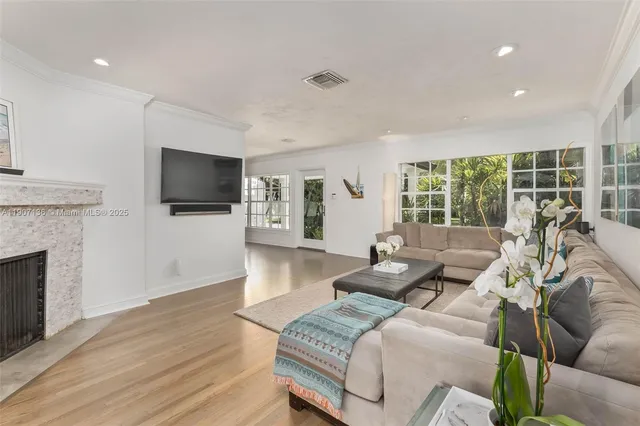 a living room with furniture a fireplace and a flat screen tv
