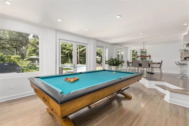 a room with pool table and windows