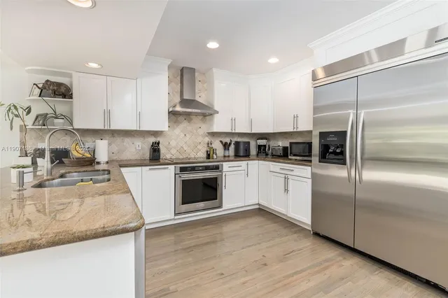 a kitchen with granite countertop stainless steel appliances and white cabinets
