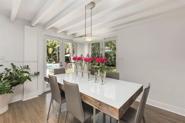 a dining room with furniture potted plants and wooden floor