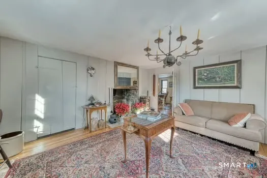 a living room with furniture a chandelier and a window