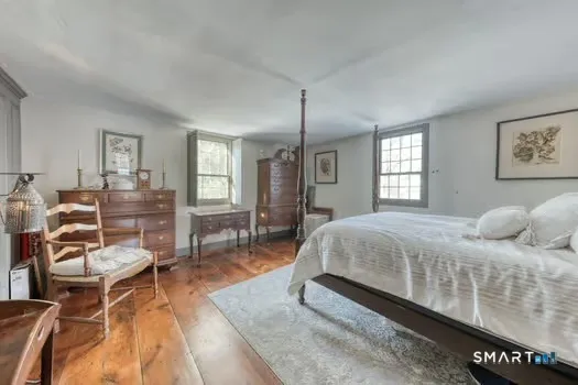 a bedroom with a bed and wooden floor