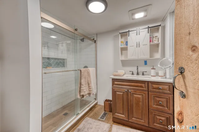a bathroom with a double vanity sink mirror and shower