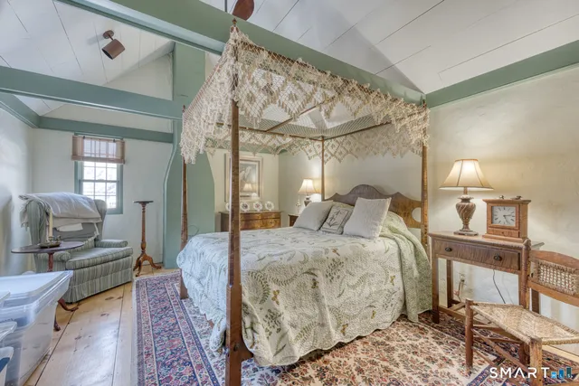 a spacious bedroom with a bed a mirror and furniture