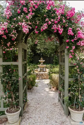 a front view of a house with a yard and fountain
