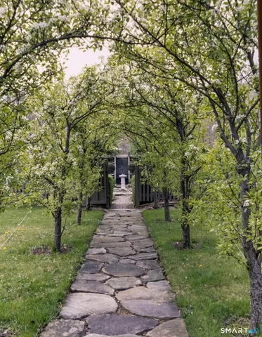 a front view of a house with a yard and trees