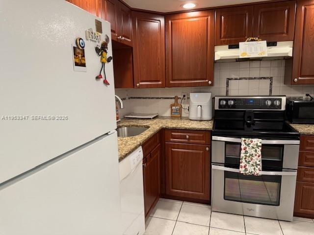 8401 West Sample Road, Unit 14 Coral Springs, FL 33065 - Photo 5 of 32 a kitchen with stainless steel appliances a stove and a refrigerator