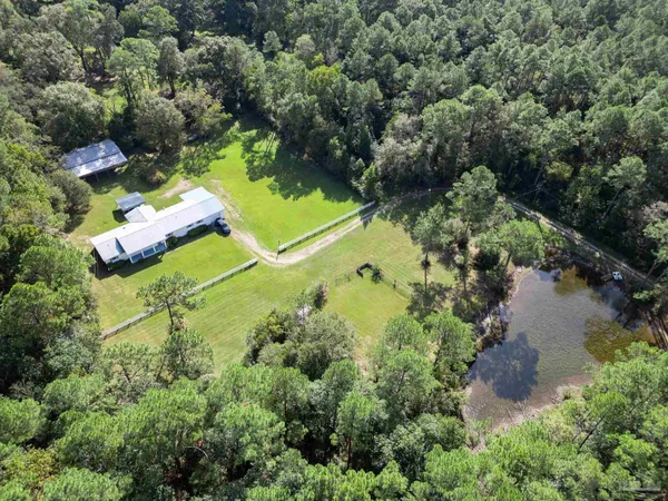 an aerial view of a house with a yard and lake view