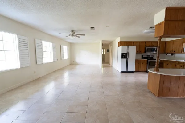 a large kitchen with a stove top oven a sink a microwave and a refrigerator