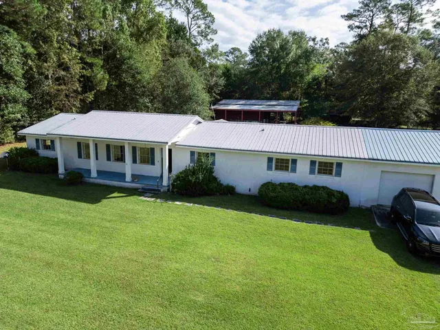 a view of a house with a yard and sitting area