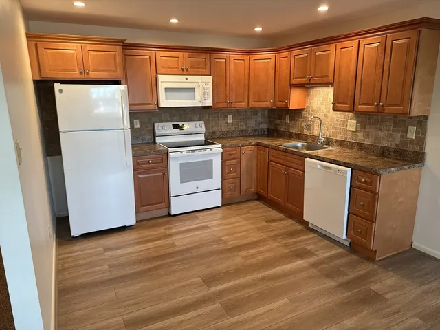 a kitchen with a refrigerator sink and cabinets