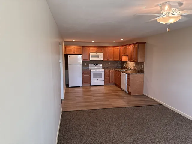 en empty room with windows and chandelier fan