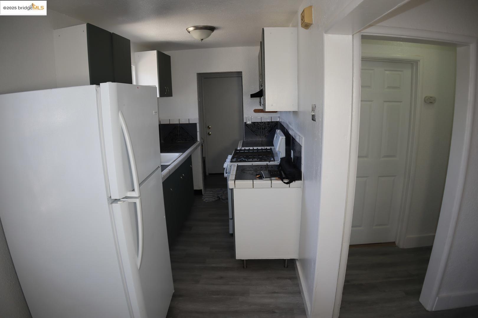 6921 Flora Street Oakland, CA 94621 - Photo 13 of 22 a room with wooden floor and electronic appliances