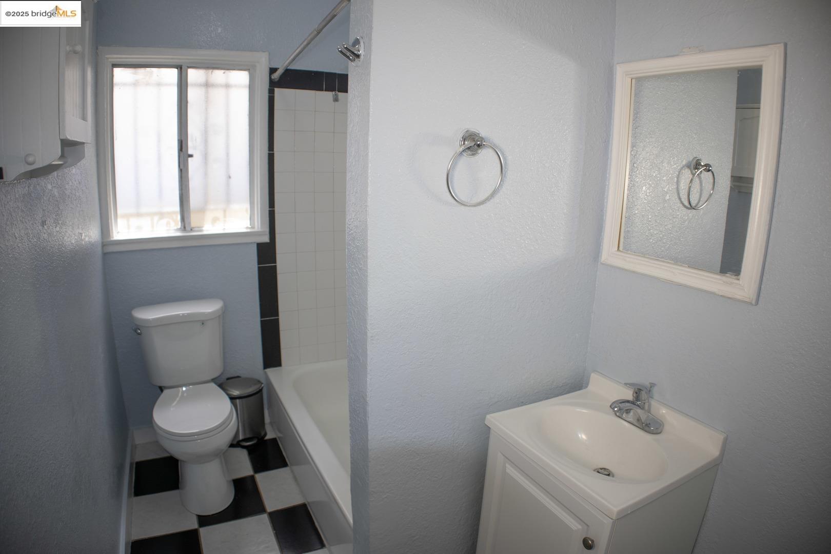 6921 Flora Street Oakland, CA 94621 - Photo 14 of 22 a bathroom with a sink toilet and a mirror